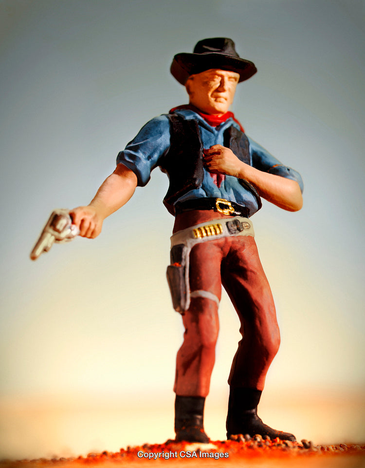 Plastic Cowboy Figurine with Revolver in Vibrant Western Landscape