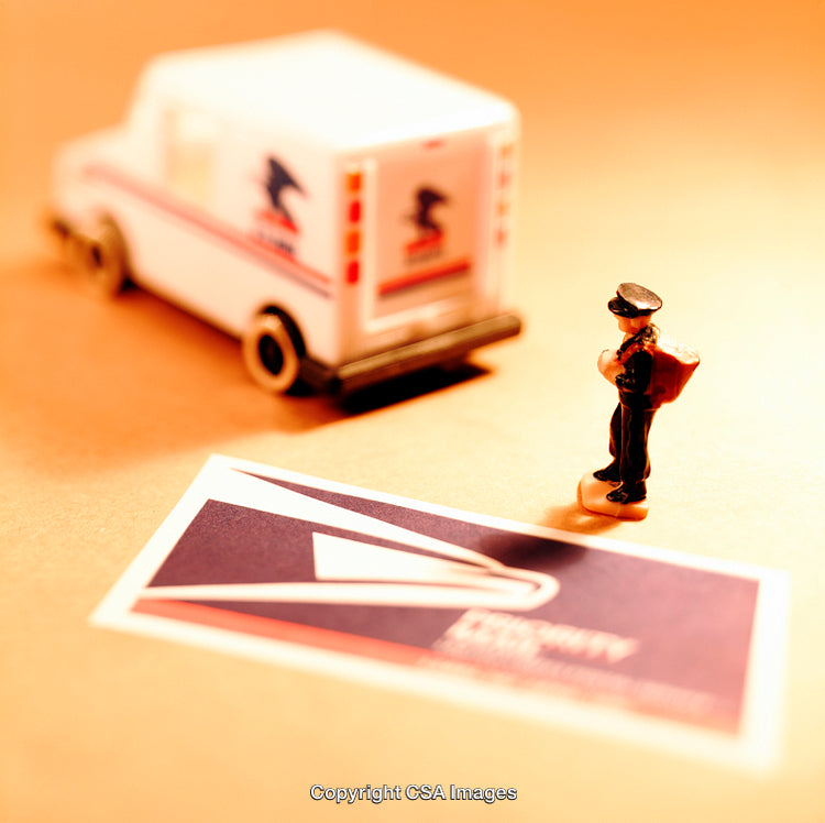 Miniature Mail Carrier with Toy Mail Truck on Wooden Surface