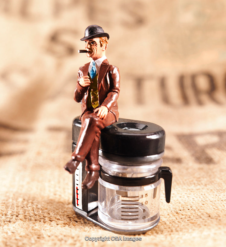 Miniature Figure of Man in Suit Sitting on Object with Artistic Style