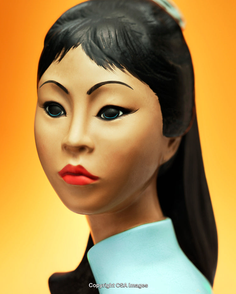 Close-Up of Decorative Figurine Against Gradient Orange Background