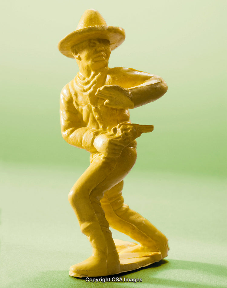 Yellow Cowboy Plastic Toy Figure on Soft Green Background