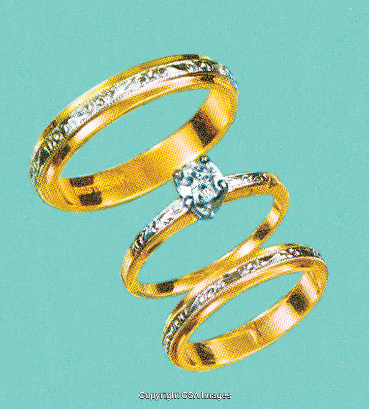 Elegant Gold Rings With Intricate Details Against a Soft Blue Background
