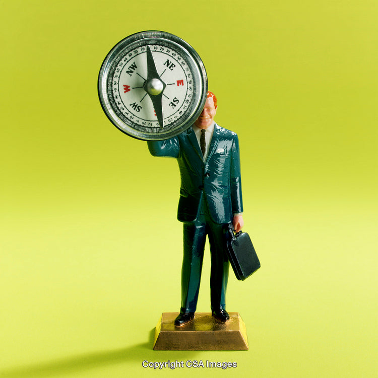 Plastic Toy of a Businessman Holding a Compass on Green Background