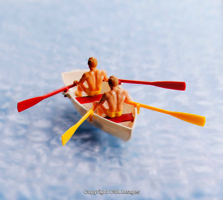 Two Toy Figures Rowing in a Boat with Colorful Oars