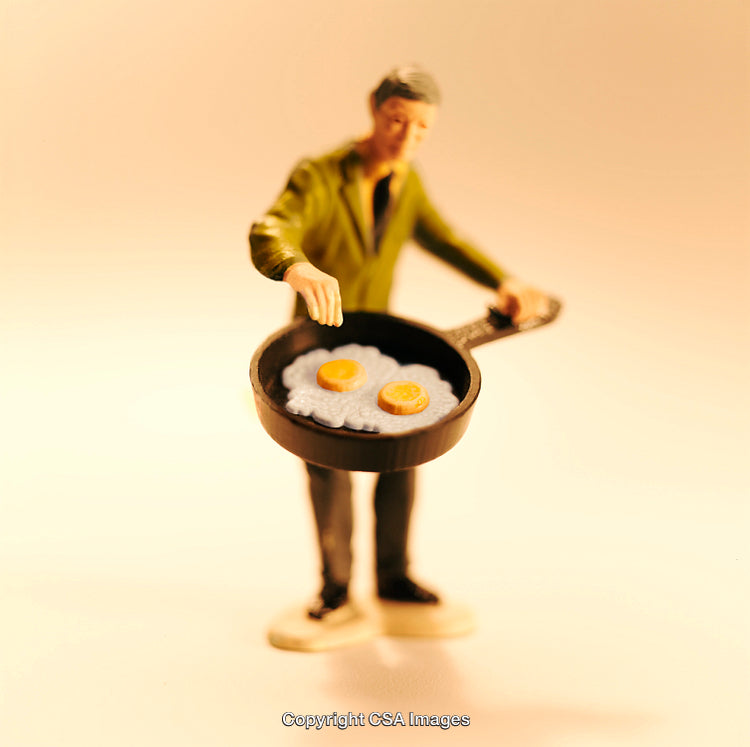 Miniature Figure Cooking Eggs in a Frypan with Artistic Lighting