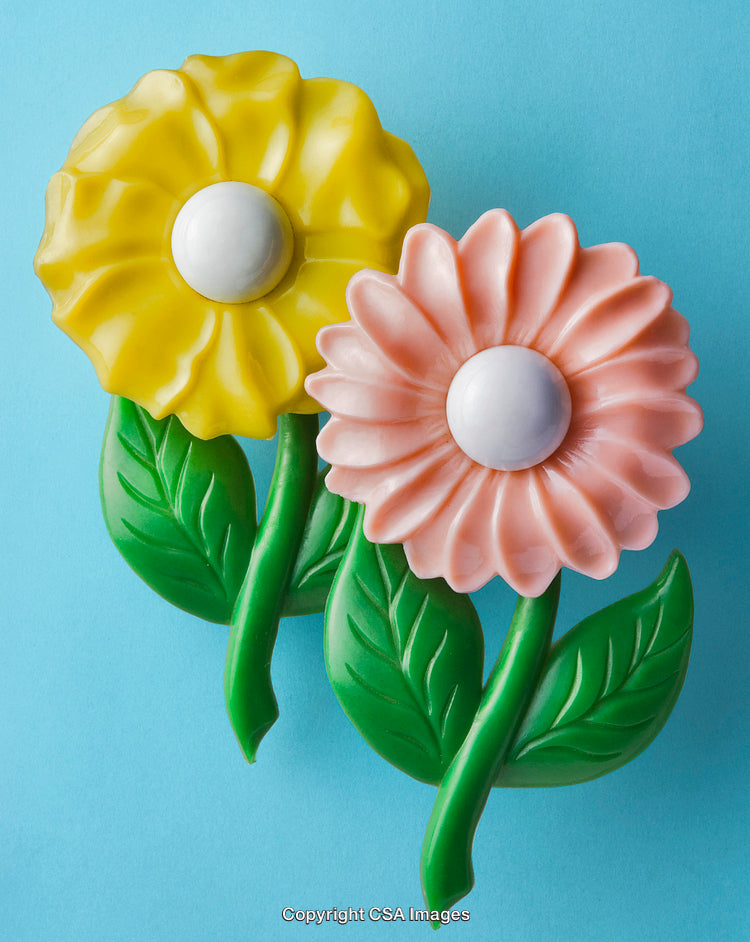 Vibrant Plastic Flower Toys in Pink and Yellow on Blue Background