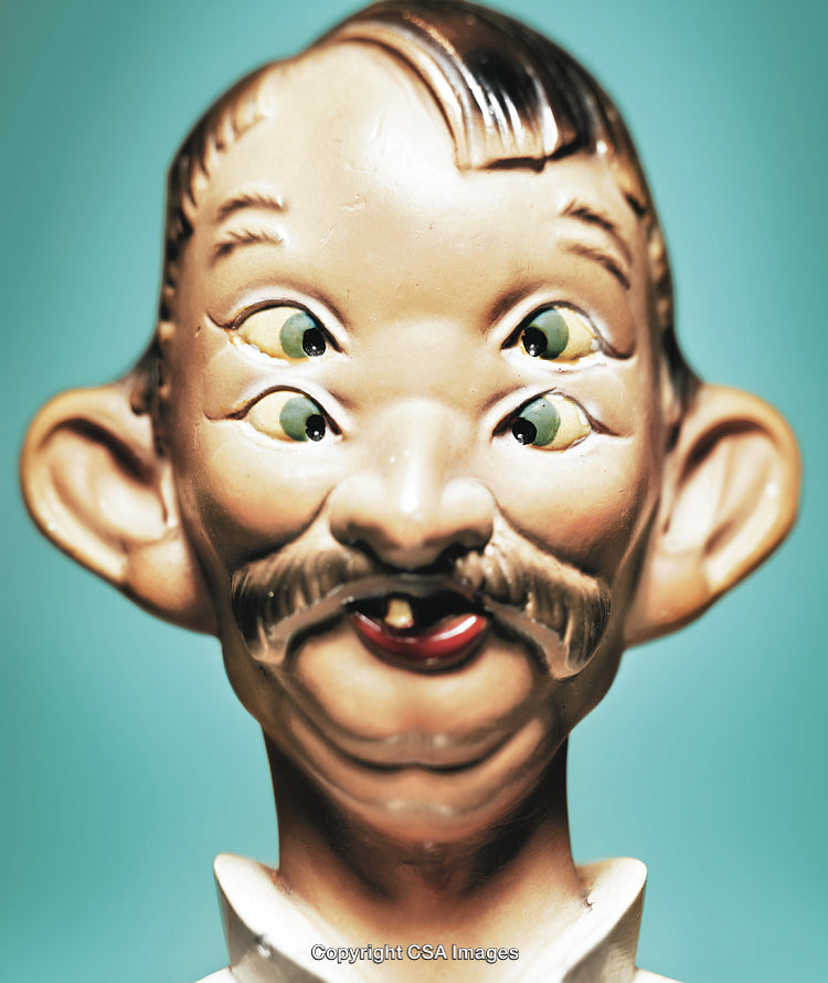 Close-Up of Unique Multi-Eyed Figurine Against Blue Background