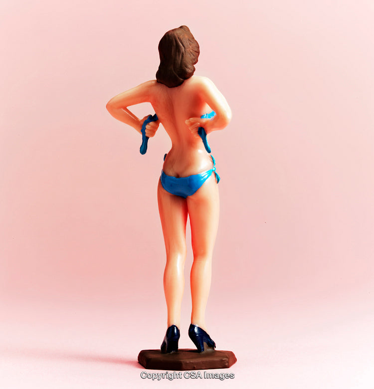 Plastic Toy With Blue Bikini On Pink Background Depicted From Behind