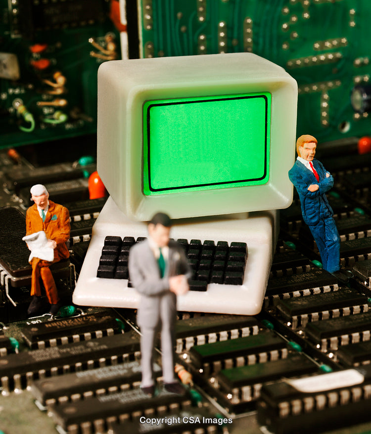 Miniature Figures on Circuit Board Beside Vintage Computer Screen Display