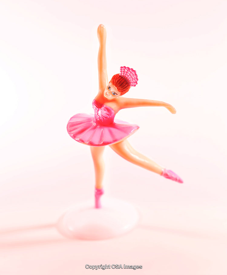 Pink Ballerina Toy Figurine Performing a Graceful Dance on Pastel Background