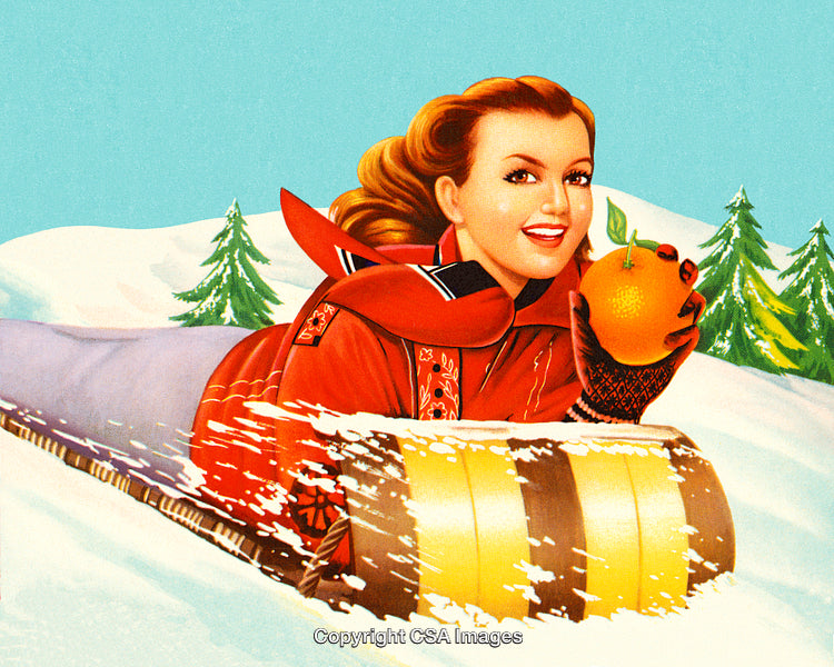 Woman Sledding Through Snow Holding an Orange with Joyful Expression
