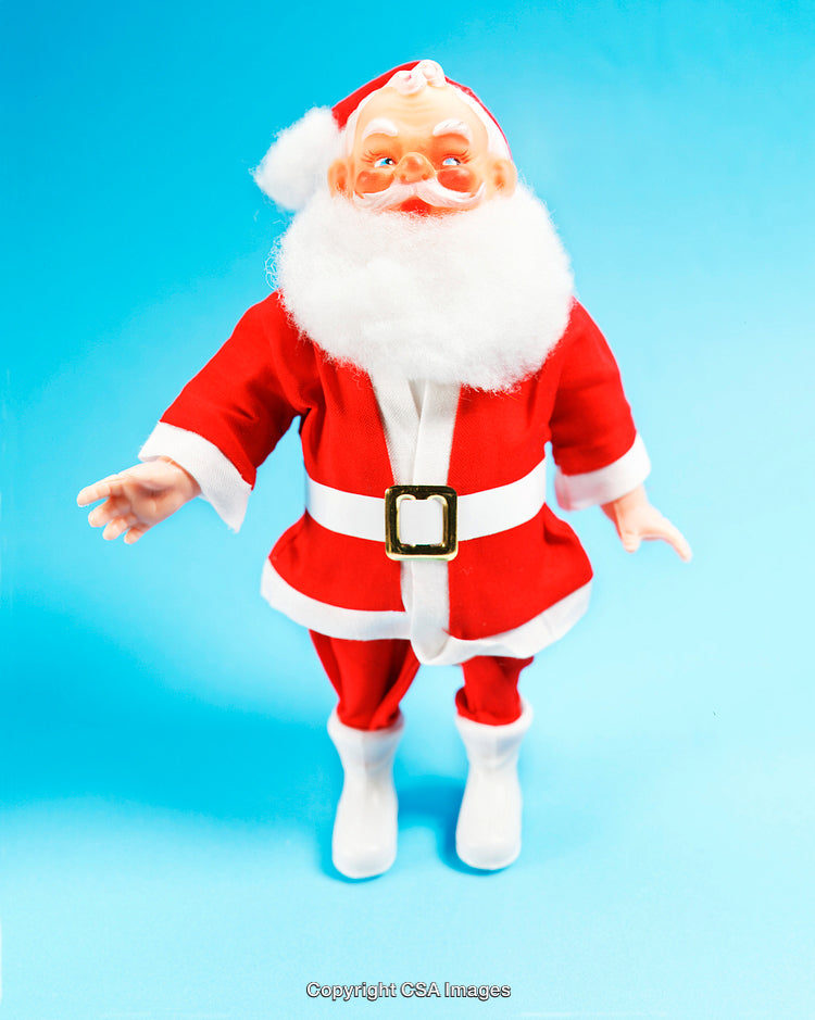 Plastic Santa Claus Toy Figure Against Bright Sky Blue Background