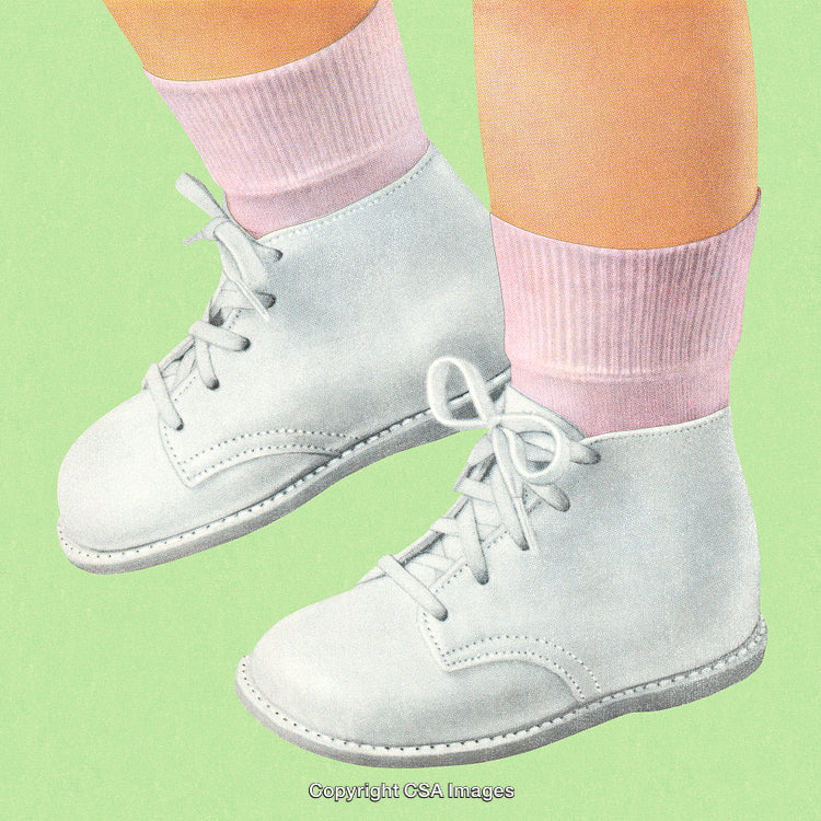 Close-Up of White Baby Shoes with Pink Socks on Green Background