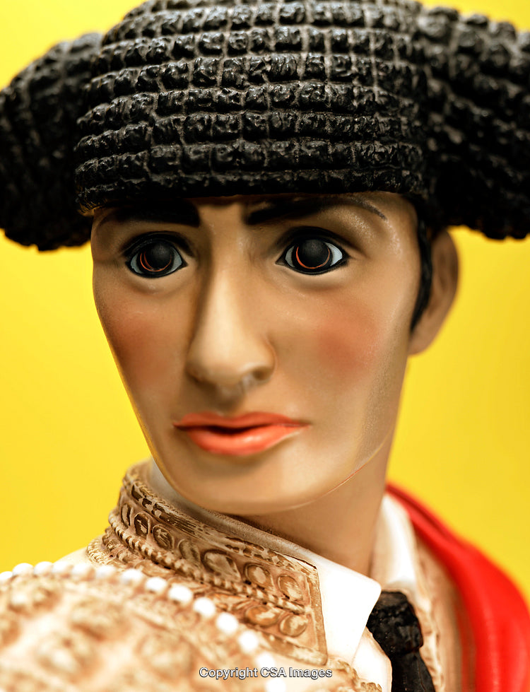 Close-Up of Plastic Matador Figure on Yellow Background