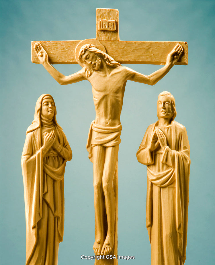 Crucifix Sculpture Representation of Jesus And Two Saints Against Blue Background