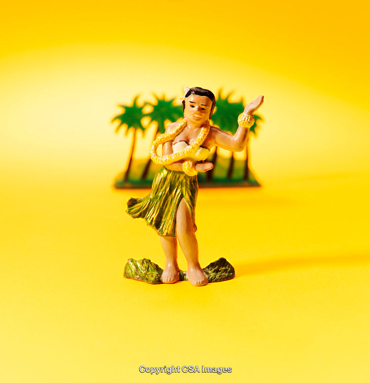 Close-Up of Hula Dancer Toy on Vibrant Yellow Background