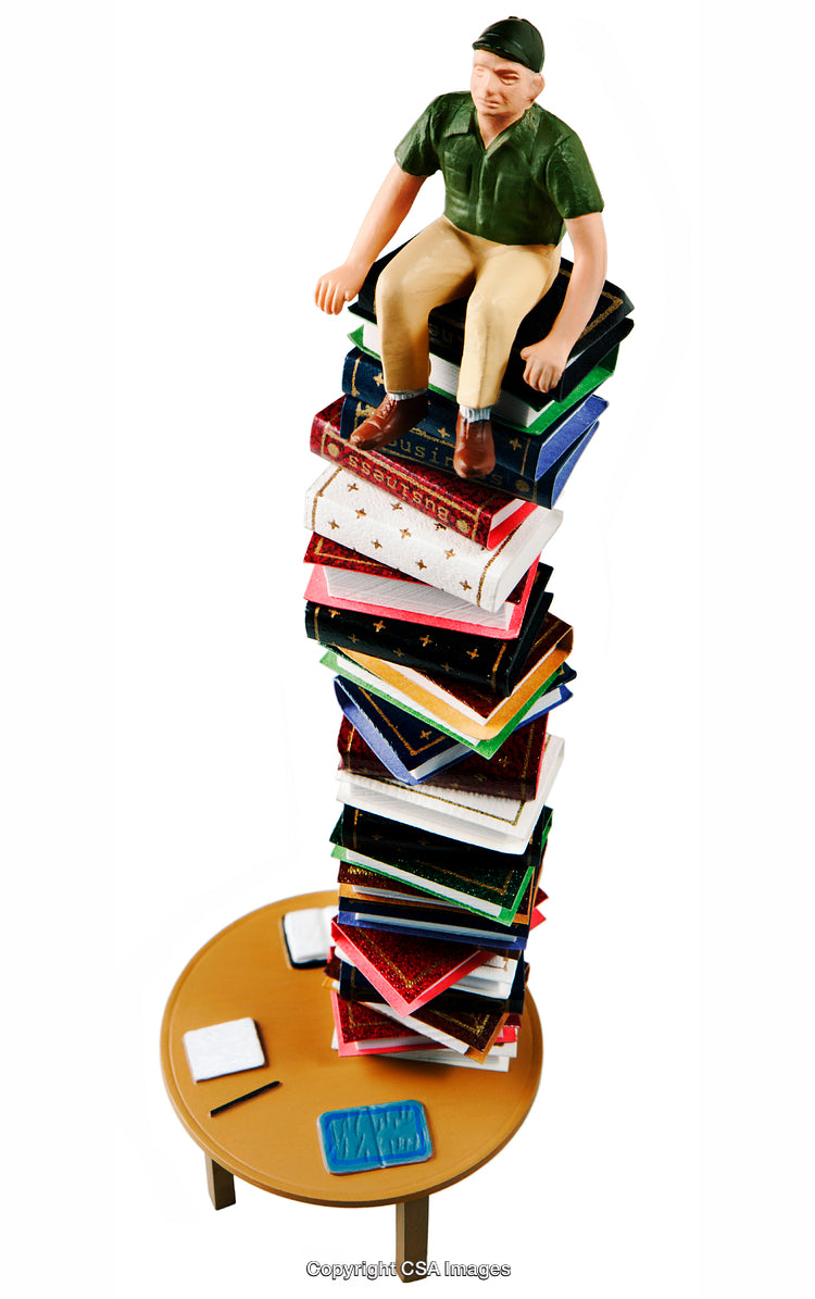 Toy Figure Sitting Atop a Tower of Colorful Toy Book Replicas