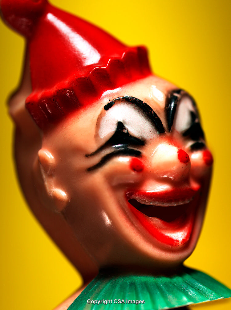 Close-Up of Smiling Clown Figurine on Vibrant Yellow Background