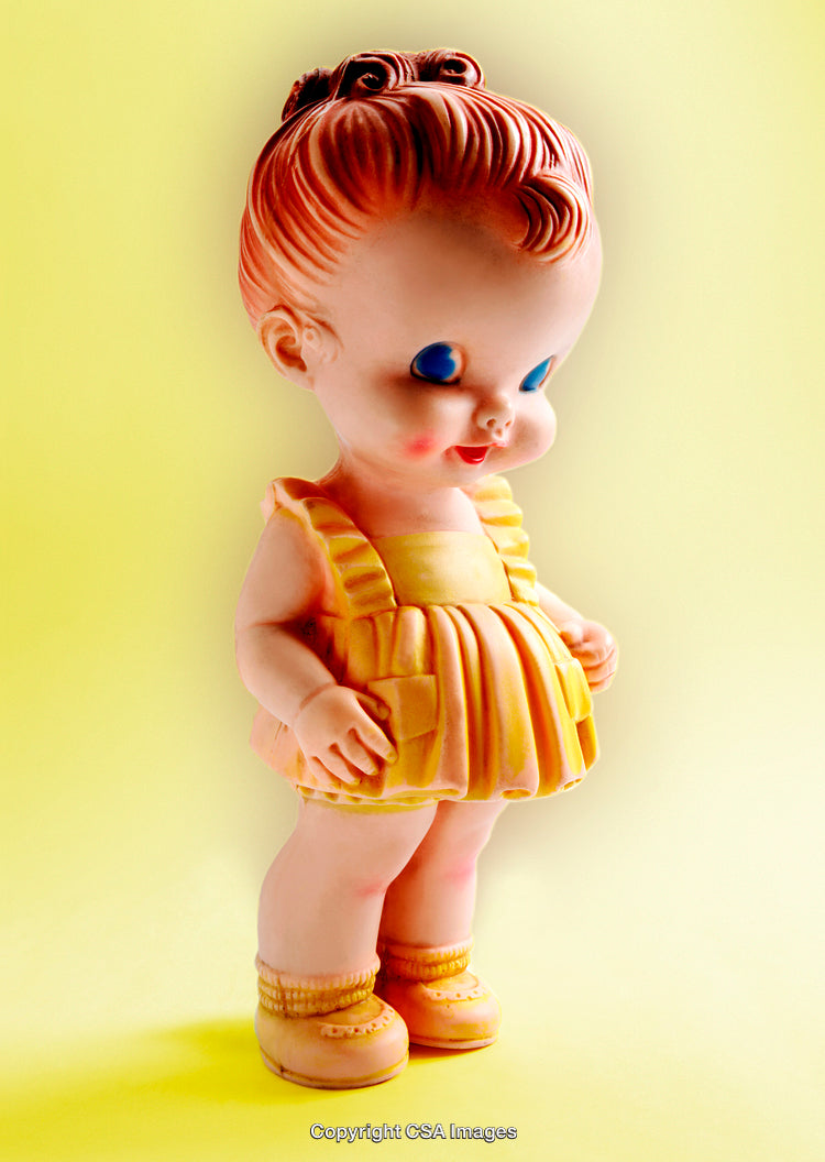 Classic Plastic Figurine in Vibrant Yellow Outfit on Light Background