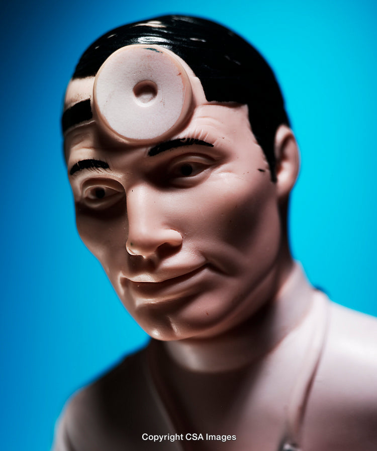 Close-Up of a Toy Doctor Figure Against a Blue Background