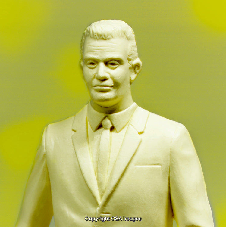 Plastic Figure of Man Wearing Suit Against Yellow Background