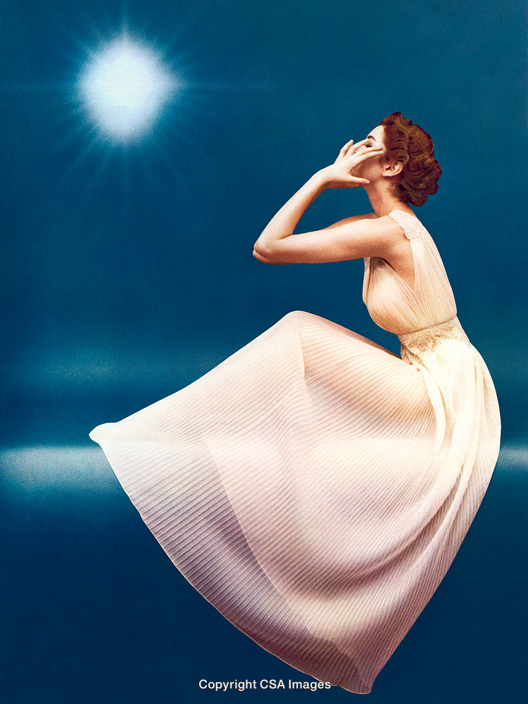 Elegant Woman in a Flowing Dress Posed Against a Vivid Blue Background
