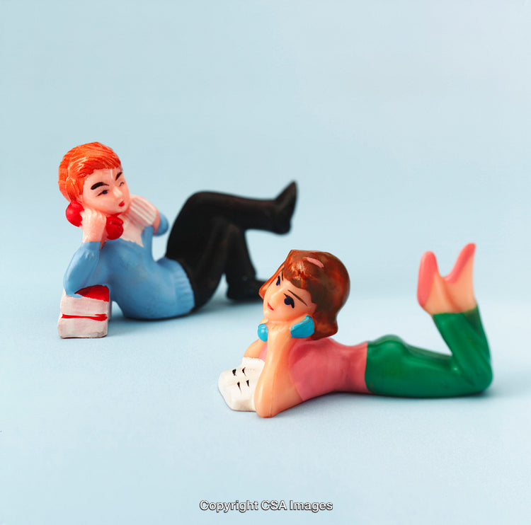 Retro Plastic Figurines Depicting a Conversing Pair on a Blue Background