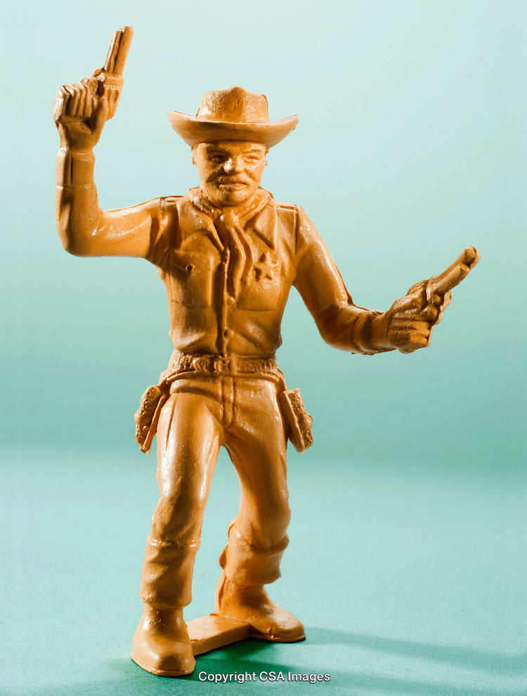 Plastic Cowboy Figure in Western Outfit with Dual Pistols on Green Background
