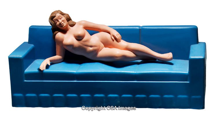 Female Figurine Reclining on Blue Couch Displayed Against White Background