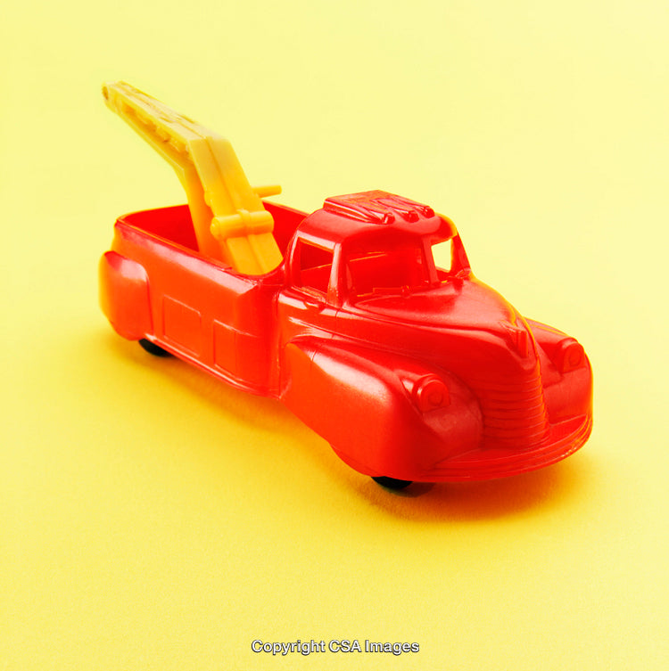 Bright Red Plastic Toy Tow Truck on Yellow Background