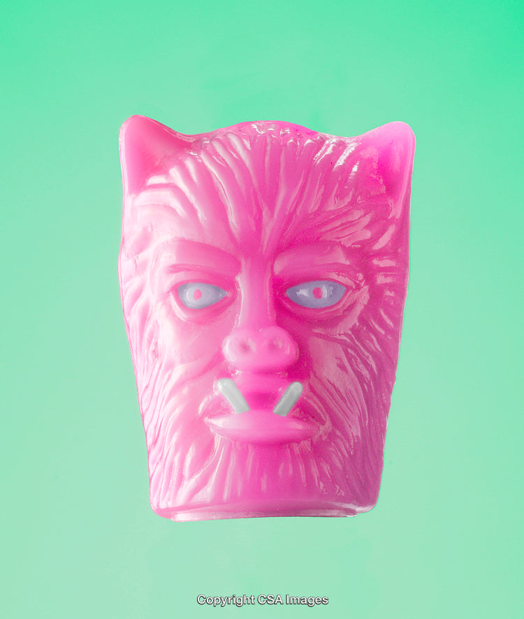 Close-Up of Pink Monster Plastic Toy on a Green Background