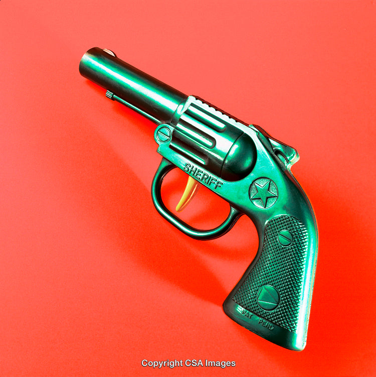 Vintage Plastic Toy Revolver Against Vibrant Red Background