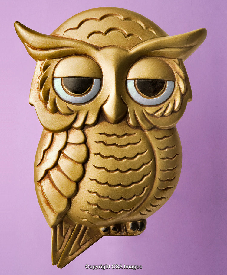 Golden Owl Figure Against a Light Purple Background