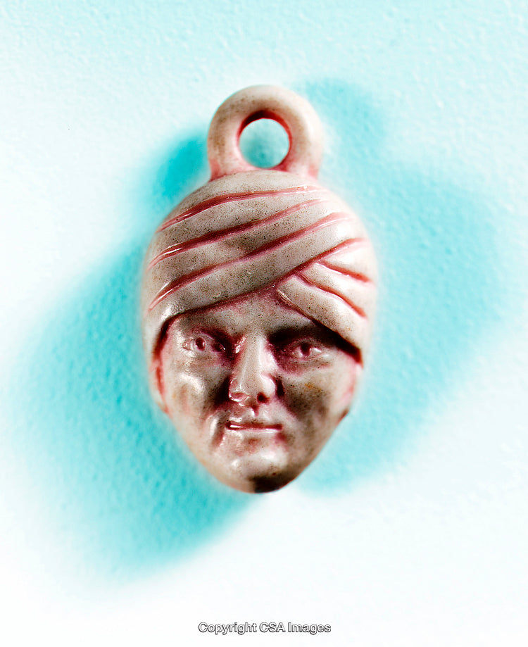Vintage Face Pendant Toy Featuring a Red Turban on a Teal Background