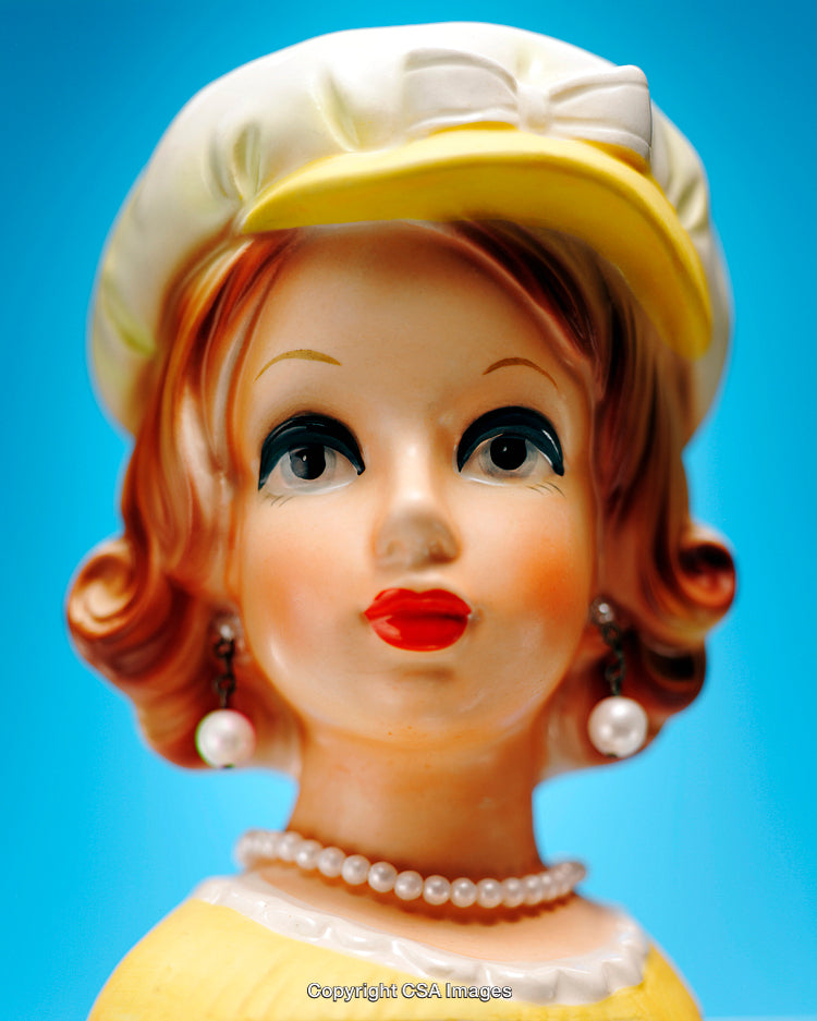 Vintage Porcelain Doll Figurine With Pearl Jewelry and Yellow Hat on Blue