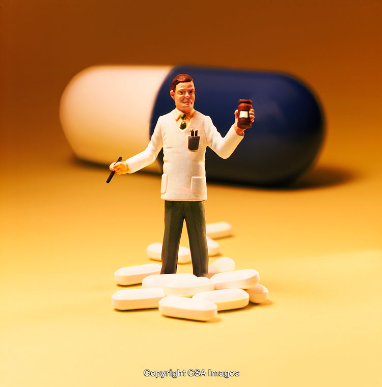 Miniature Doctor Figurine Surrounded by Pills and a Large Capsule