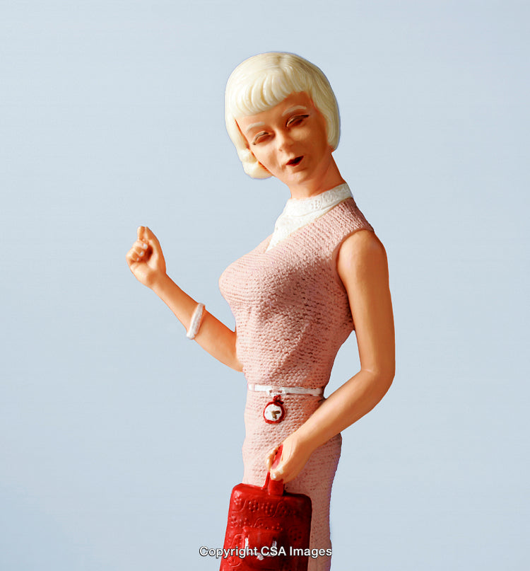 Vintage Style Figurine of a Woman Holding a Red Bag on Light Background