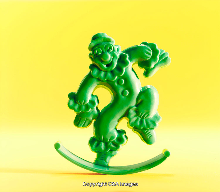 Colorful Green Plastic Clown Toy on Bright Yellow Background
