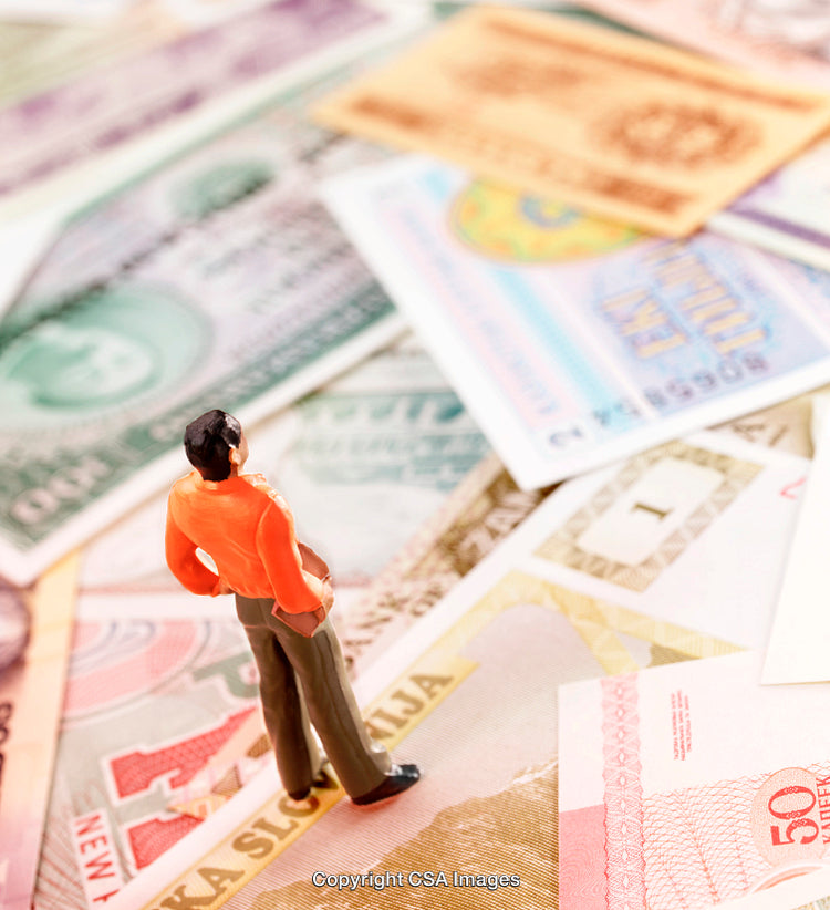 Miniature Figure Standing on a Background of Colorful Different Currency Notes