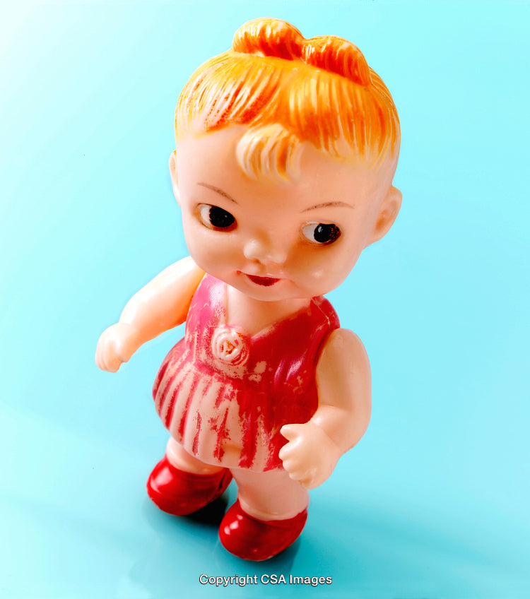 Vintage Plastic Doll Figure in Pink Dress on Blue Background