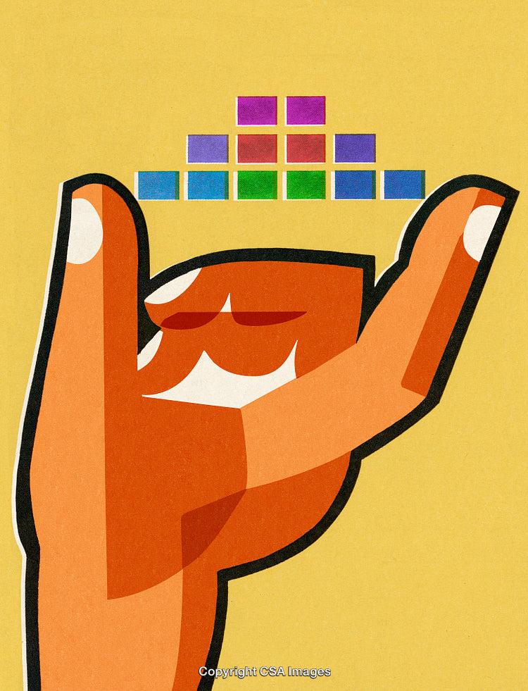 Hand Balances Colorful Blocks Against Yellow Background for Artistic Contrast