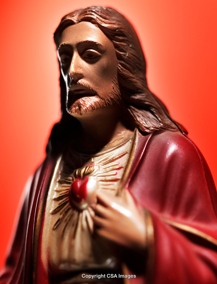 Sacred Heart Religious Figurine Against a Vivid Orange Background