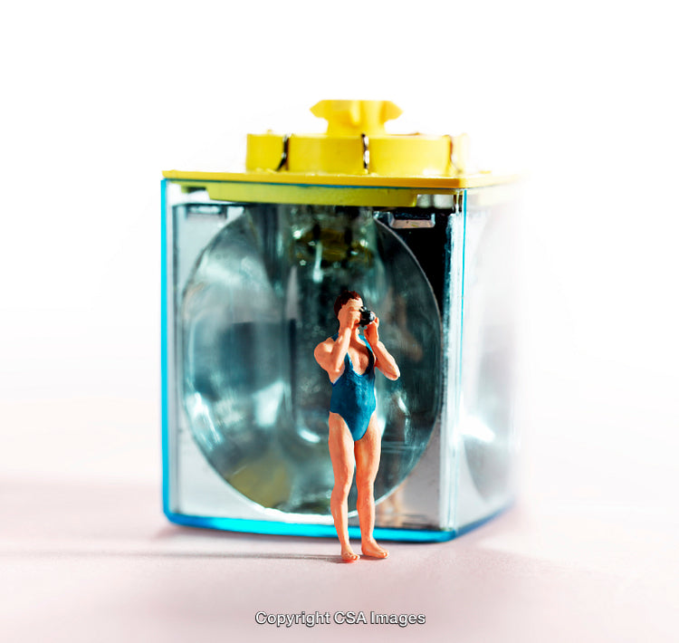 Miniature Figure in Swimwear Capturing Scene with Camera