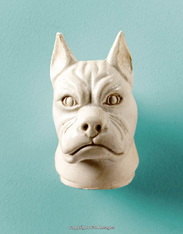 Close-Up of Dog-Shaped Sculpture Against a Blue-Green Background