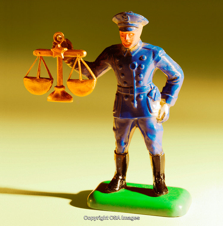 Toy Police Officer Holding a Golden Scales of Justice Figurine