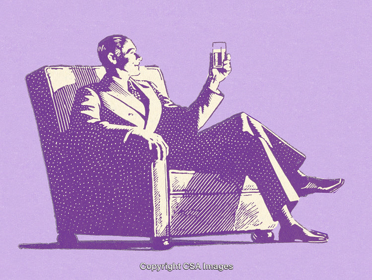 Elegant Man Relaxing in a Chair While Holding a Glass