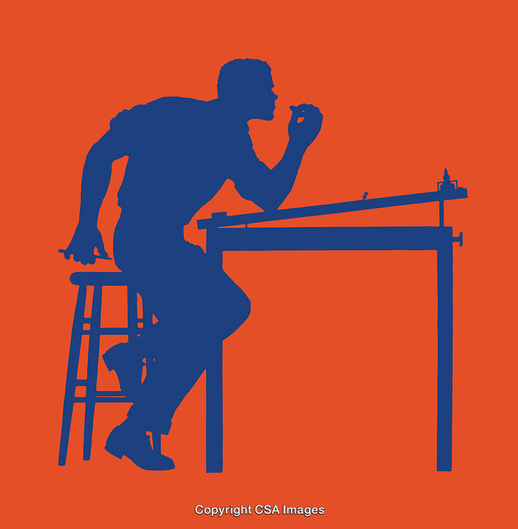 Silhouette of Designer Working at Drafting Table Against Bright Orange Background