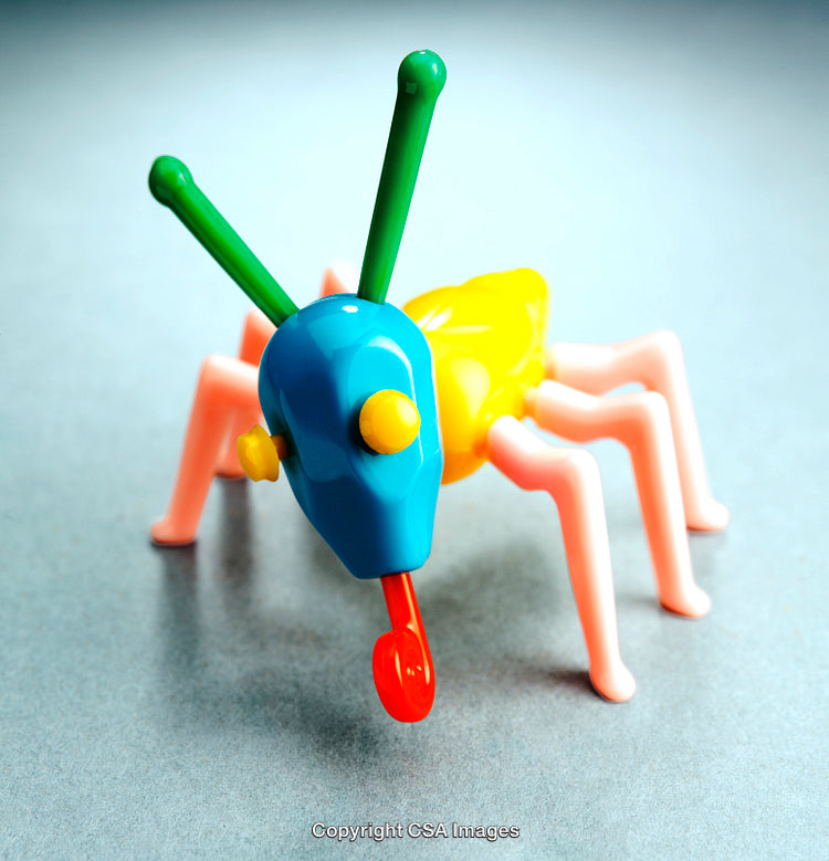 Colorful Plastic Toy Insect with Legs and Antennae on Gray Surface